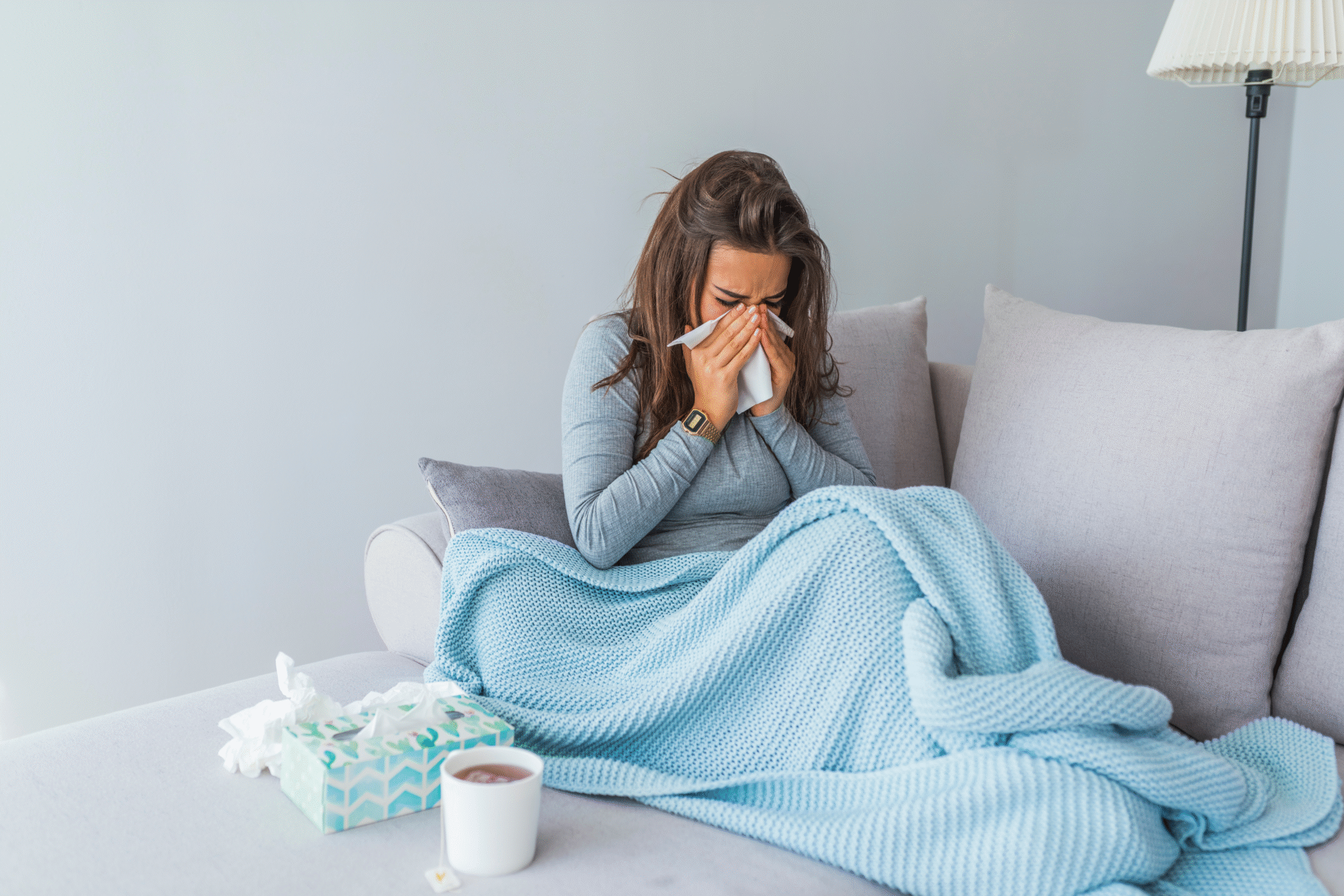 lady sick and sneezing on the couch